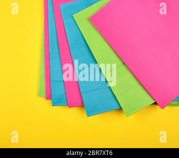 Multi-farbiges Papier Einkaufstüten auf gelbem Hintergrund, flach Stockfoto