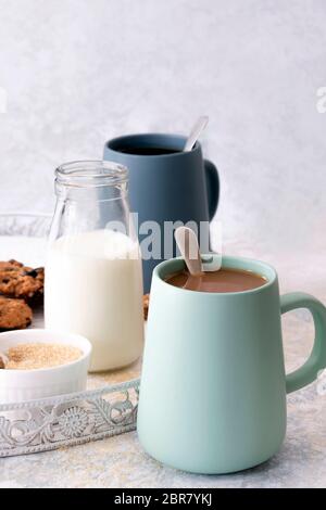 Tassen mit weißem und schwarzem Kaffee mit Datekeksen. Stockfoto