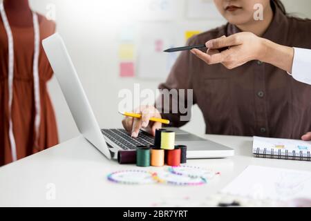 Zwei junge Männer, die als Modedesigner und Skizzen und erhält Stoff Beratung in einer benutzerdefinierte Schneider Stockfoto
