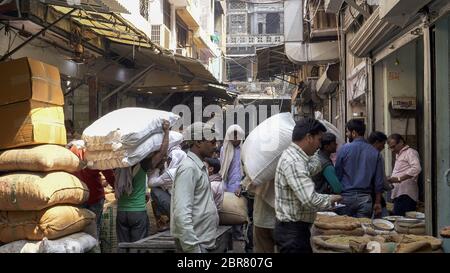 DELHI, INDIEN - 14. MÄRZ 2019: Arbeiter, die Gewürzsäcke tragen, auf dem Markt im chandni chowk-Distrikt im alten delhi, indien Stockfoto