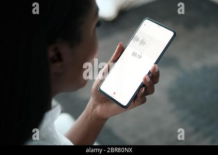 Schwarze Frau, Die Sprachnotiz Auf Dem Mobiltelefon Aufführt Stockfoto