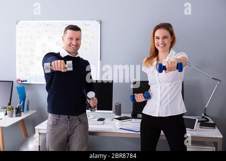 Nahaufnahme der männlichen und weiblichen Unternehmer Trainieren in Office mit Hanteln Stockfoto