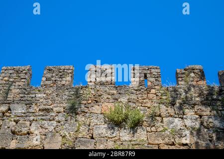 Schlupflöcher der Kalksteinmauer. Die Festungsmauer der alten Festung in Antalya Stockfoto