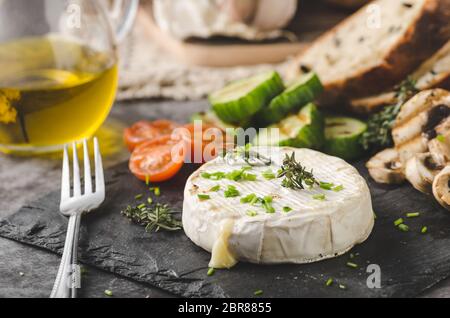 Gegrillter Käse mit Gemüse, Olivenöl, Knoblauch und Kräuter Stockfoto