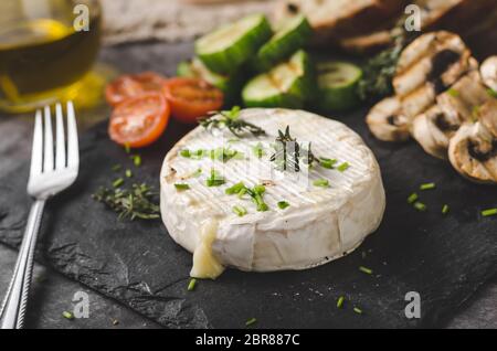 Gegrillter Käse mit Gemüse, Olivenöl, Knoblauch und Kräuter Stockfoto