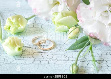 Blumenstrauß mit zwei goldene Ringe an den Holz- Hintergrund Stockfoto