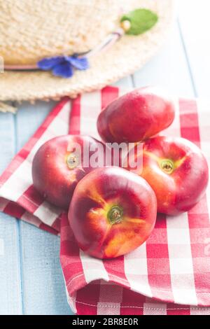 Reife flache Nektarinen auf karierter Serviette. Stockfoto