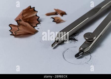Closeup Makro Detail einer Geometrie bleistift Kompass und Bleistift schärfen Holzspäne auf weißem Papier mit einem gezeichneten Kreis-Konzept der schulischen Bildung Stockfoto