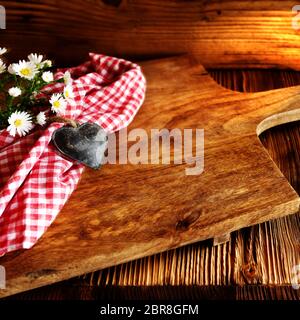 Rustikales Schneidebrett aus Holz mit bayerischer Dekoration für einen oktoberfest Hintergrund Stockfoto