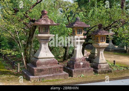 Der Blick auf die drei traditionellen kaku-doro Steinlaternen entlang des Fußweges am Kitano Tenmangu Schrein. Kyoto. Japan Stockfoto