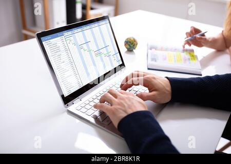 Der Geschäftsmann Hände Arbeiten auf das Gantt-diagramm auf Laptop über Schreibtisch am Arbeitsplatz Stockfoto