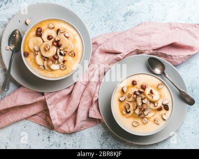 Zwei Schüssel mais Grieß Brei mit Banane, Haselnuss und verbrannte Butter Honig. Süße Polenta oder maismehl Brei. Ideen und Rezepte für sehr schnelle Kinder b Stockfoto