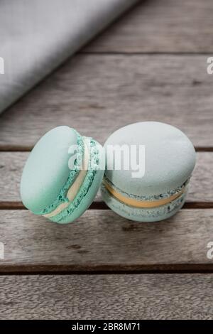 Hausgemachte frische bunte Französisch Macarons Kuchen, auf natürlichen Beton Holzhintergrund. Food Konzept mit Kopierraum. Vertikales Bild. Stockfoto