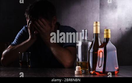 Flaschen mit alkoholischen Getränken und die Abbildung von einem betrunkenen Mann Stockfoto