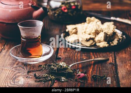 Esslöffel himbeere Kräutertee und bereit, Tee in armudu Glas mit Platte von Sonnenblume halva Stockfoto