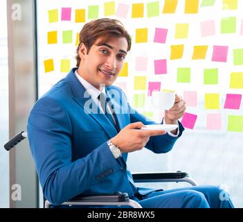 Jungen gutaussehenden Mann im Rollstuhl mit vielen widerstreitenden Prioritäten Stockfoto