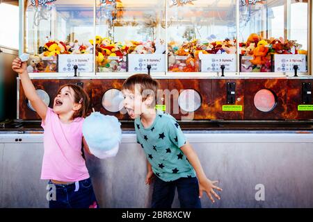 Foto von einem Bruder und Schwester essen eine grosse Zuckerwatte in einem Vergnügungspark. Stockfoto