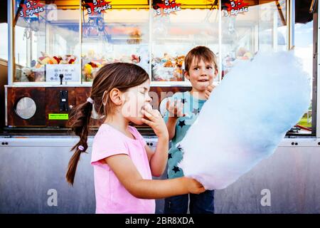 Foto von einem Bruder und Schwester essen eine grosse Zuckerwatte in einem Vergnügungspark. Stockfoto