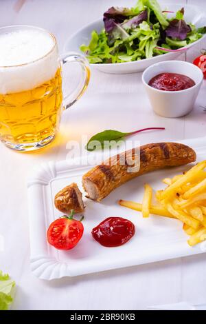 Leckere Bratwurst mit Brötchen und Bier Stockfoto