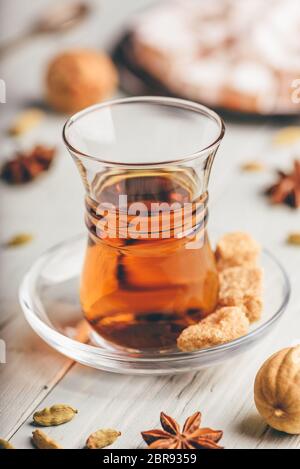 Tee in arabischen Glas mit Turkish Delight Rahat Lokum und verschiedene Gewürze über Holz- Oberfläche Stockfoto