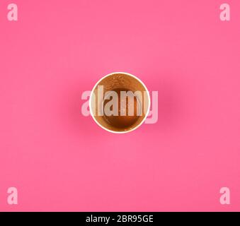 Leere red Pappbecher unter Kaffee steht auf rosa Hintergrund, Ansicht von oben Stockfoto