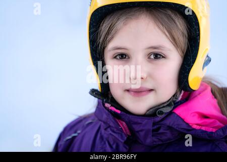 Winter Portrait eines kleinen Mädchens tragen gelbe Ski Helm beim Skifahren Lektion Stockfoto