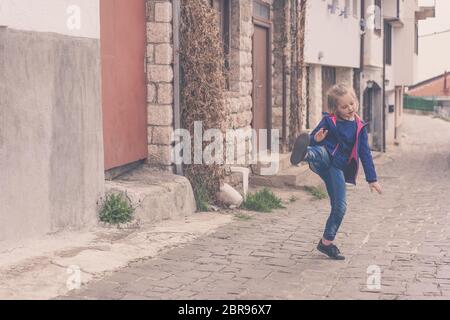 Kleines Mädchen Spaß üben Kicks auf einer Straße in Ohrid, Mazedonien Stockfoto