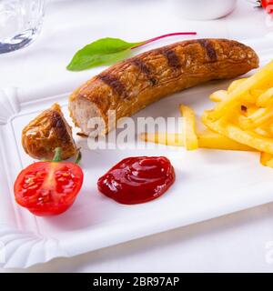 Leckere Bratwurst mit Brötchen und Bier Stockfoto