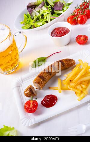 Leckere Bratwurst mit Brötchen und Bier Stockfoto