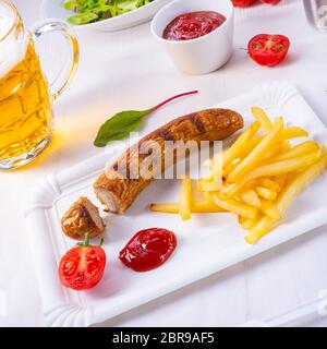 Leckere Bratwurst mit Brötchen und Bier Stockfoto