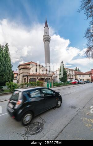 Ohrid, Mazedonien - April 2019: Eigenes schwarzes Auto fahren vor der Moschee Minarett in Ohrid Stockfoto