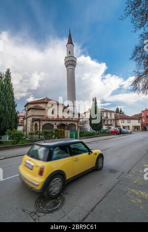 Ohrid, Mazedonien - April 2019: Kleine gelbe Eigenes Auto vor der Moschee Minarett fahren in Ohrid Stockfoto