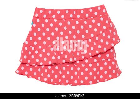 Rock Sommer isoliert. Nahaufnahme von einem schönen roten kleine Mädchen kurze Polka Dot Rock auf einem weißen Hintergrund. Kinder und Kids Fashion. Makro. Stockfoto