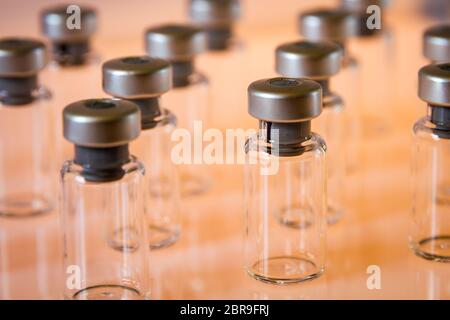 Gruppe von Impfstoff Glasflaschen auf orange Hintergrund Stockfoto