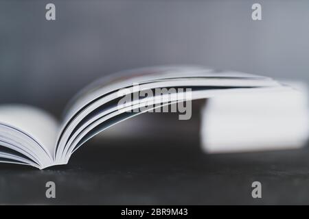 Bildung und Selbstverbesserung, Stapel von Büchern mit einem offenen auf ihnen geschossen aus Augenhöhe mit geringer Schärfentiefe Stockfoto