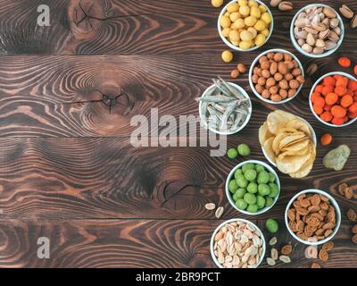 Sortiment von verschiedenen Snack für Bier, Wein, Party. Erdnüsse in Coconut Glasur, grüne vasabi, rote scharfe Chili, gelben Käse Glasur, Chips, Pistazie, Stockfoto