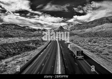 Blick auf eine endlose gerade Straße durch die Wüste in den USA läuft Stockfoto