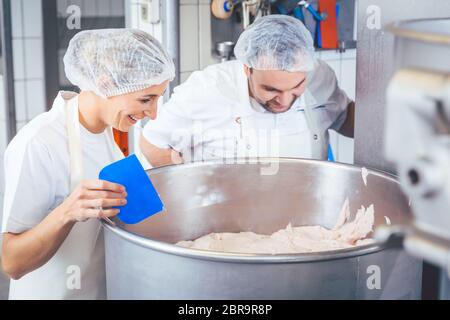 Metzger Mann und Frau arbeiten zusammen Hackfleisch in Maschine Stockfoto