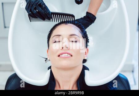 Artisan Friseur fleißig Haare waschen von Kunden Frau Stockfoto