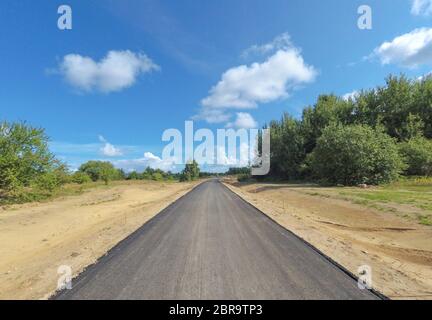 Land asphaltierte neue Straße im Feld. Stockfoto