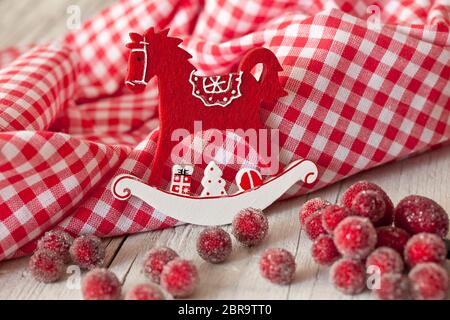 Dekoratives Weihnachtsfest nordischer Stil mit rockiger Pferdeornamentik in rot-weiß kariertem Stoff Stockfoto