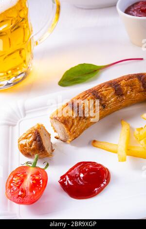 Leckere Bratwurst mit Brötchen und Bier Stockfoto