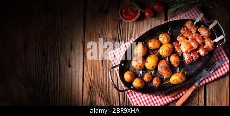 Rustikale Datteln mit Speck und junger gerösteter Kartoffel. Stockfoto