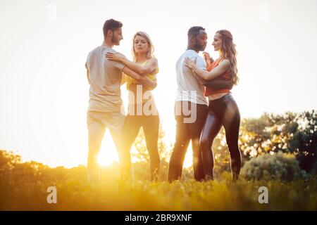 Zwei Paare tanzen fortgeschrittene Kizomba bewegt sich während Sonnenuntergang in einem Park Stockfoto