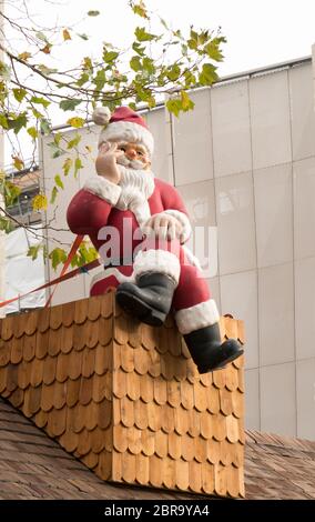 Ein Vater Weihnachten Abbildung Dekoration sitzen auf einem hölzernen Schornstein Stockfoto