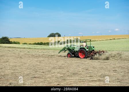 Landwirt Traktor schaltet das Gras für eine bessere Trocknung Stockfoto