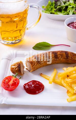 Leckere Bratwurst mit Brötchen und Bier Stockfoto