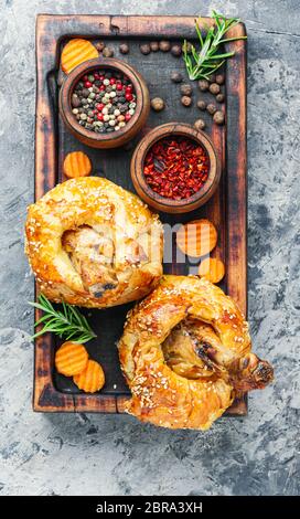 Hähnchenschenkel in Blätterteig. Hühnerbein in Blätterteig auf Schneidebrett. gebackene Chicken Drumsticks Stockfoto