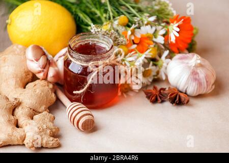 Ernte Kräuter, Blume Knoblauch, Zitrone, Ingwerwurzel, Honig im Glas - Konzept der saisonalen Winter Herbst Herbsttage, Getränk für kalte Grippe Treament, Alter Stockfoto