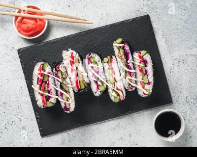Vegane sushi Sandwich onigirazu mit Pilzen und Gemüse. Gesund essen Rezept und Idee. Bunte japan Sandwich onigirazu mit Rotkohl, radis Stockfoto